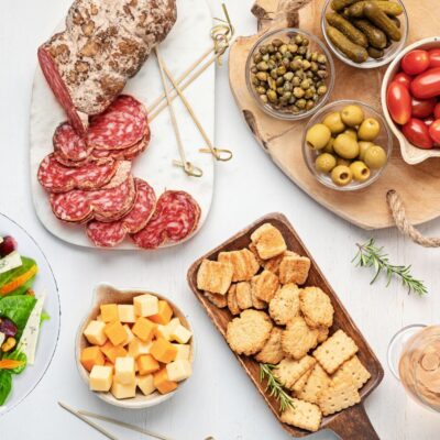 Antipasti italian cuisine, image features crackers, salad, cold cuts, olives, cherry tomatoes and more