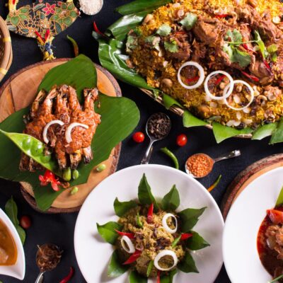 A table of nasi briyani, sambal udang petai, rendang, daging kerutuk, daging tetel and pucuk paku masak lemak. Buffet.
