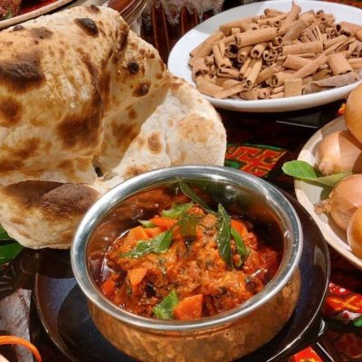 dinner buffet Ramadan, pratha and butter chicken (indian style) and onion on a batik cloth table