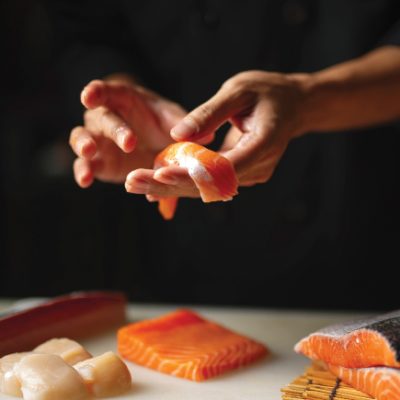 omakase, chef hand with freshly sliced salmon