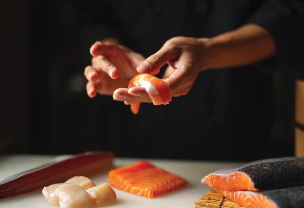 omakase, chef hand with freshly sliced salmon