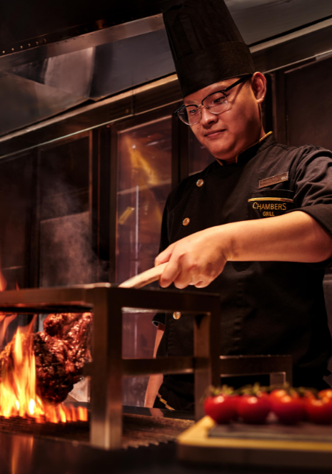 The photo shows a Chambers Grill chef cooking up a storm.