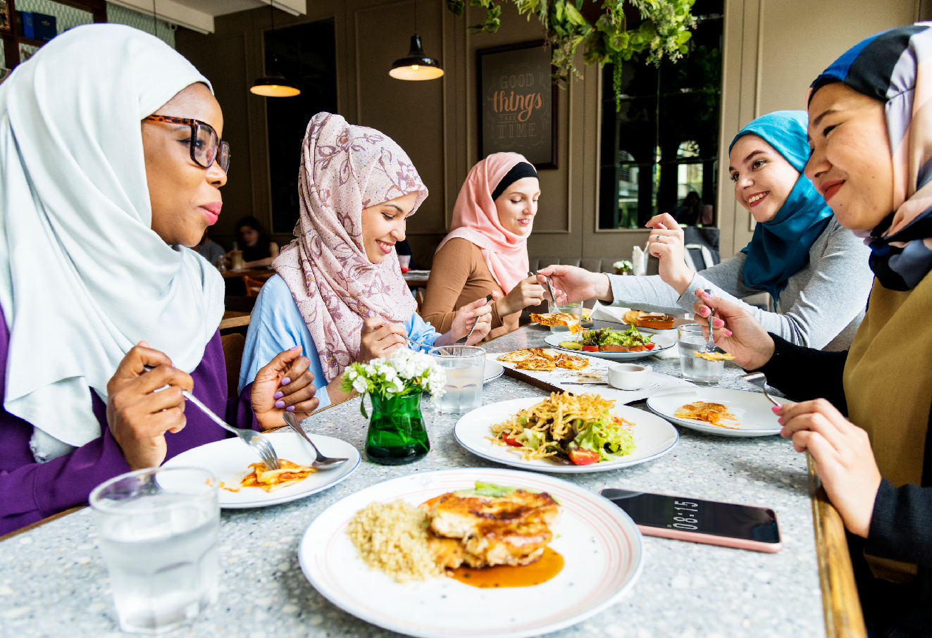 A group of Muslim women are having lunch together.