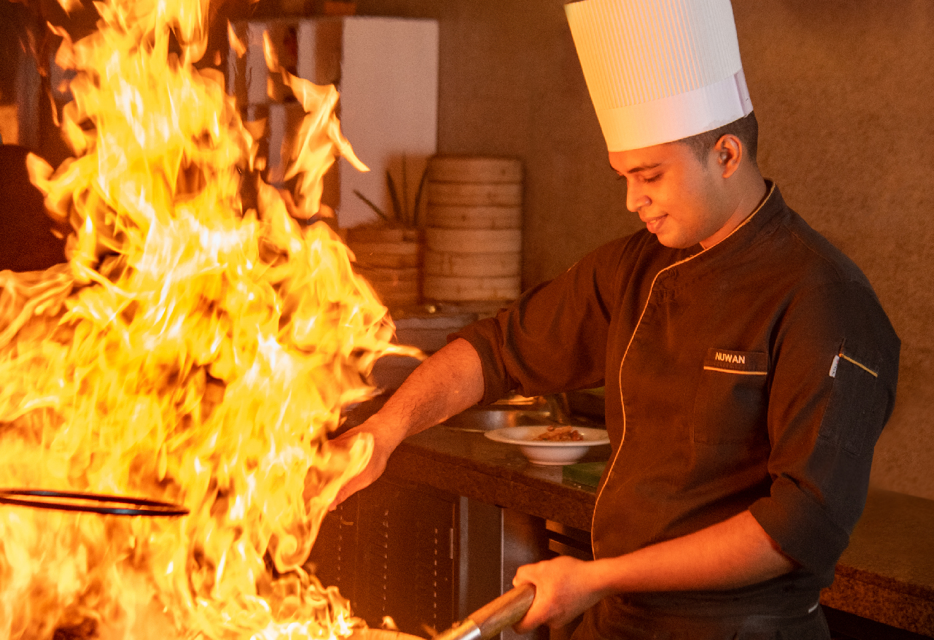 Chef in action with flame wok