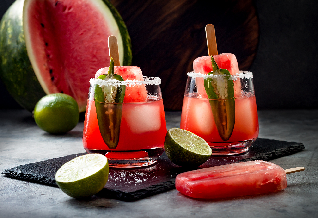 The photo shows two iced popsicles dipped in two seperate glasses of drink.