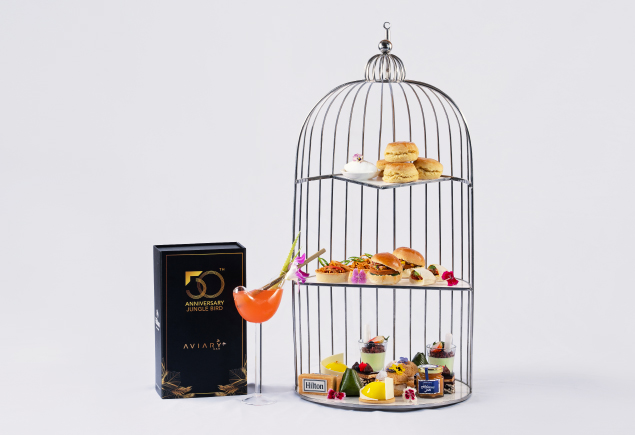 An afternoon tea set with a glass of the Jungle Bird cocktail.