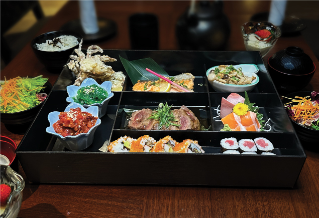 A bento set inclusive of fresh sashimi, sushi, teppanyaki beef, mushrooms, soft shell crab and seaweed salad.