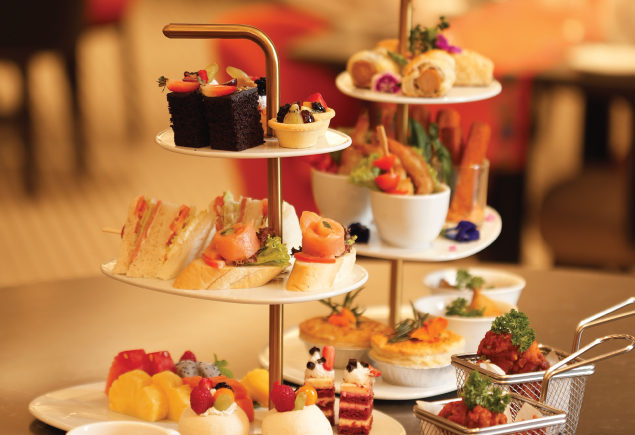 High tea set with freshly made scones, sandwiches, fruit tarts, dainty cakes, and more