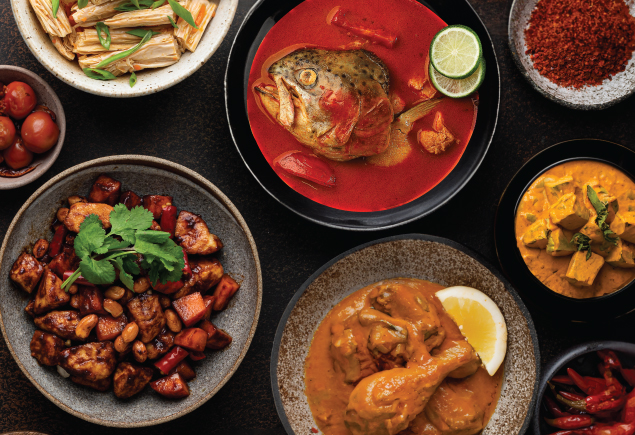 Five different types of Malaysian food such as fish head curry, curry chicken, stir-fried Chinese style chicken, stir-fried vegetables and curry lamb.