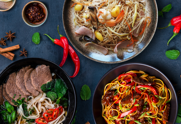 Three bowls of different Asian noodle dishes on the table along with the ingredients.