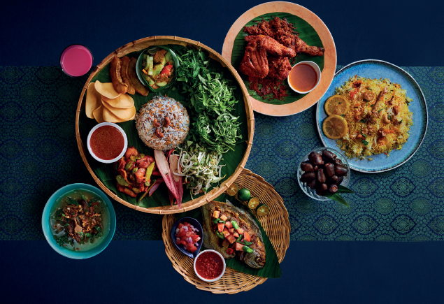 Five authentic Malay dishes such as Nasi Ulam, Ayam Goreng Berempah, Ikan Bakar, Sup Kambing and Nasi Minyak. On the side, there's a glass of Sirap Bandung and a bowl of Kurma.