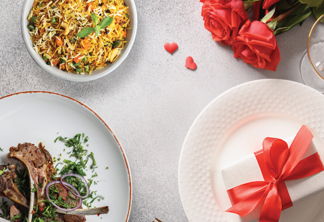 The photo shows a Valentine's day table setup with briyani rice, lamb rack and grilled prawns.