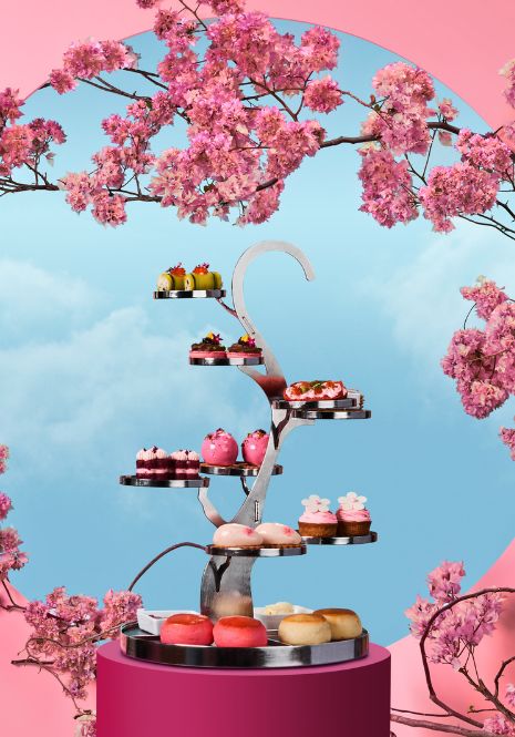 The photo shows a high tea stand shaped like a tree with branches. On the high tea stand, it has a variety of sweet and savoury finger bites.