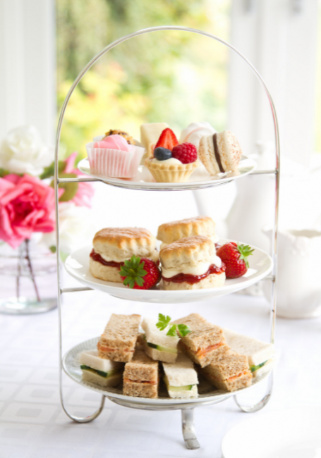 Three tier high tea set with assorted desserts and finger bites.