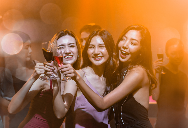 Three ladies are clinking their glasses together