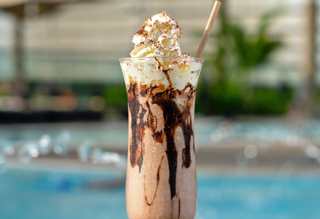 A glass of iced milo with whipped cream on top.