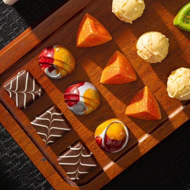 A variety of chocolates in different shapes and colors.