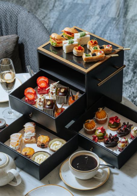 A full afternoon tea set with assorted savory bites and desserts paired with champagne, coffee or tea.