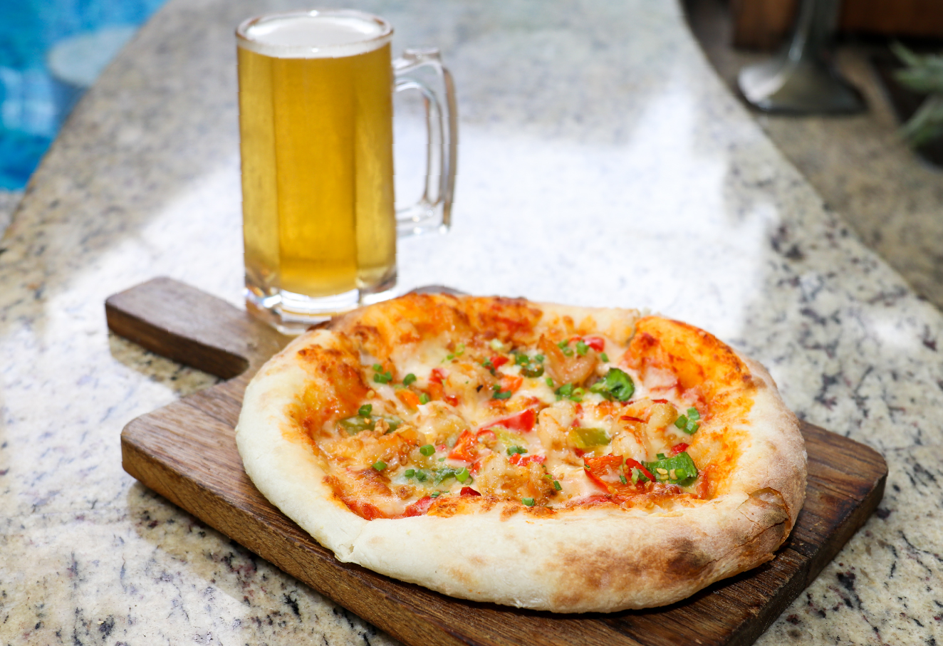 The photo shows a whole pizza and a mug of beer.