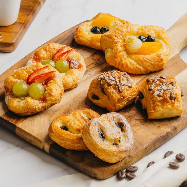 Five different types of pastries on a chopping board.