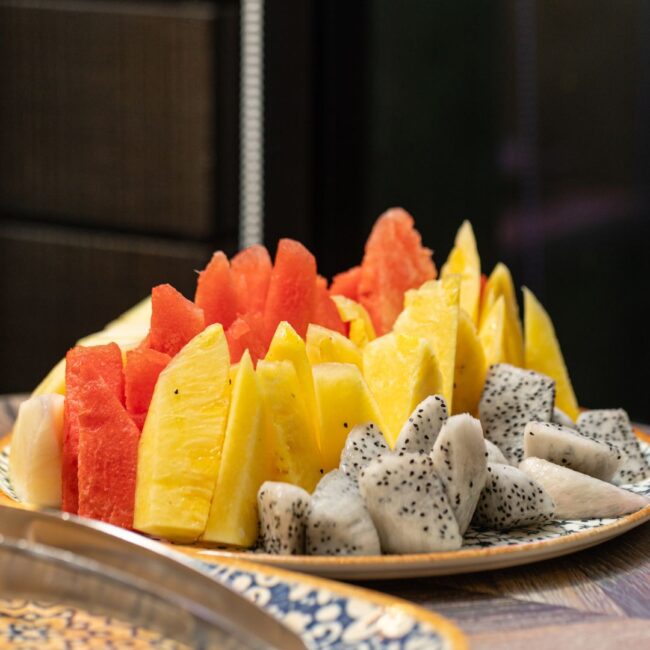 A variety of sliced fruits such as watermelon, pineapple and dragonfruit.