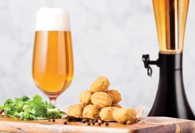 A glass of beer, a tower of beer and a plate of snacks.