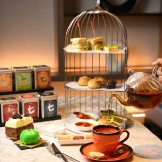 A high tea set with sweet and savory delights and tea.