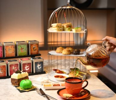 A high tea set with sweet and savory delights and tea.