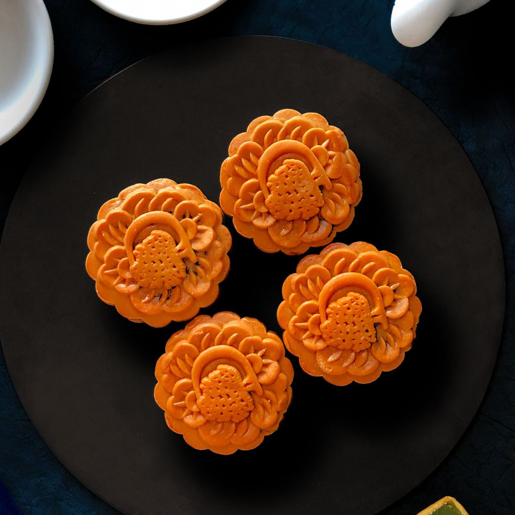 Four pieces of baked mooncakes with DoubleTree logo stamped on it.
