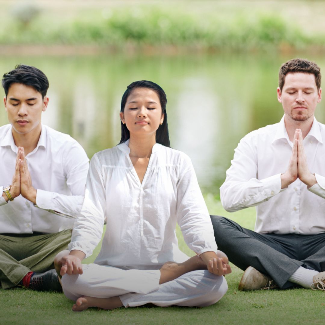 A group of 3 people are meditating.